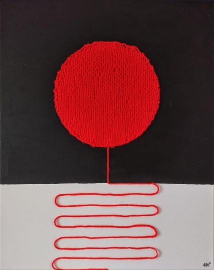 Ree knitted circle on black background over a winding red thread affixed to the white part of a canvas